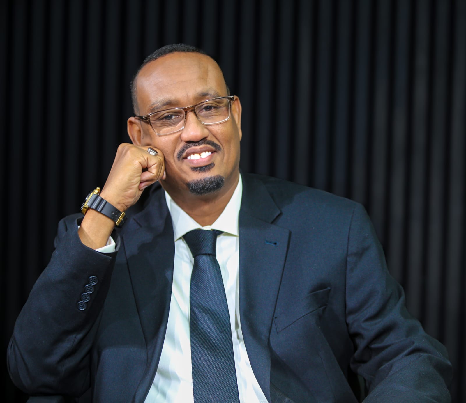 Istoosi Media host wearing a black suit